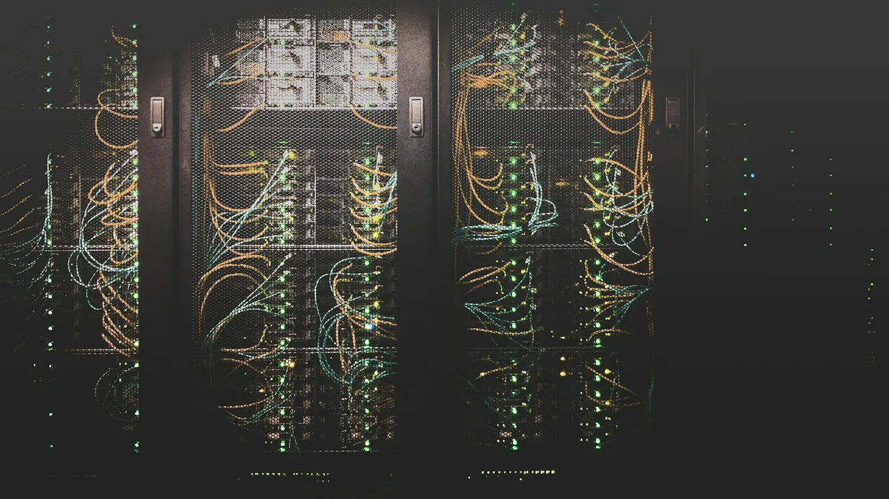 Server racks in a data centre with bundles of yellow and blue network cables and status lights.