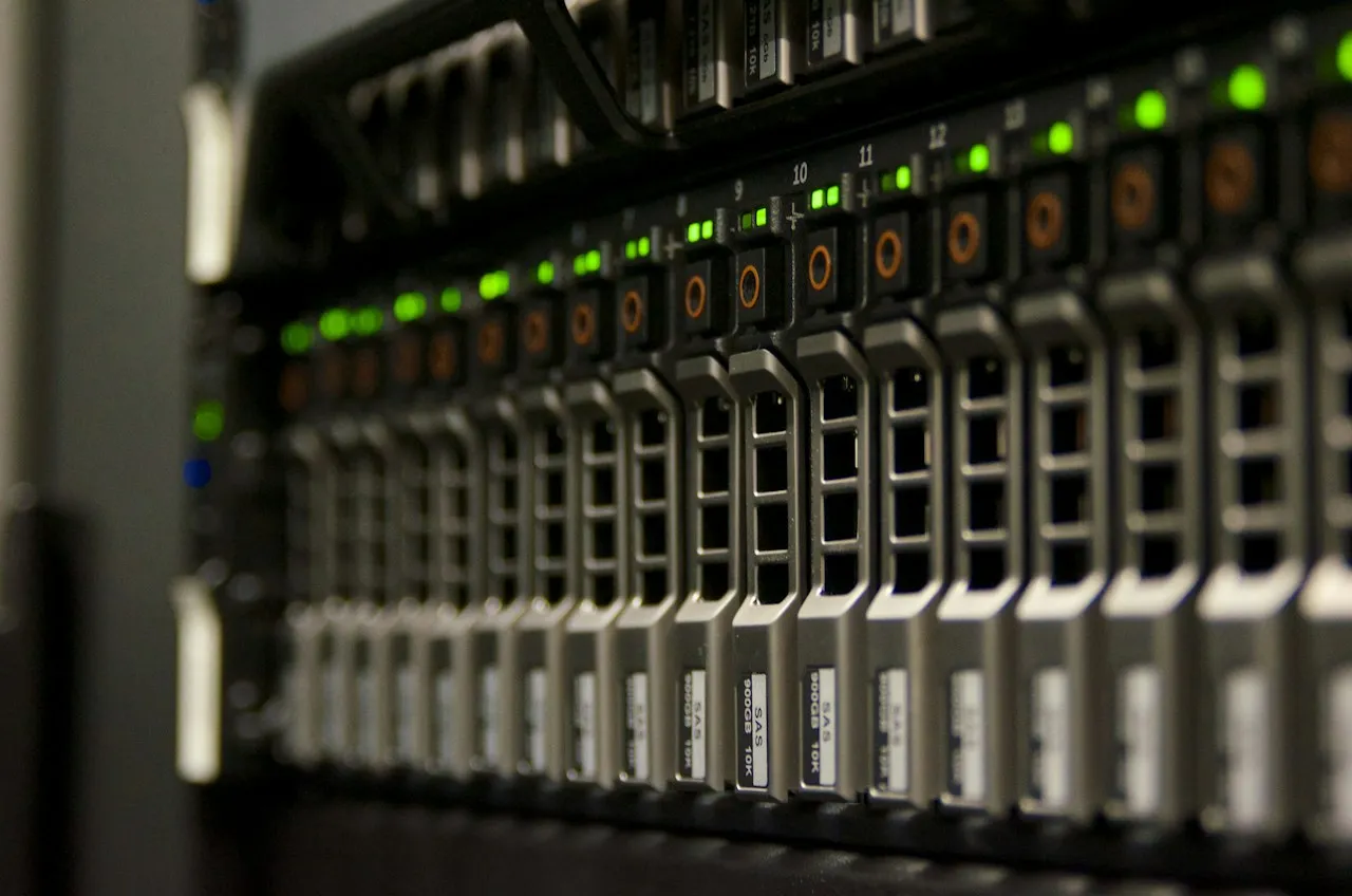 Close-up of a rack server's front panel, with a row of drive bays and green status lights.