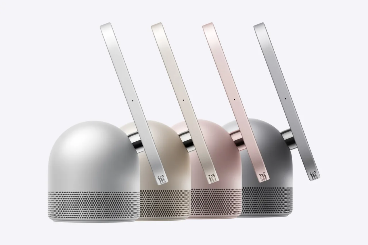 Apple's press image of four HomeView displays seen from the side. Each is a thin square screen on a metal hinge above a dome-shaped speaker base with a perforated grille. They are silver, pale gold, pink and dark grey.