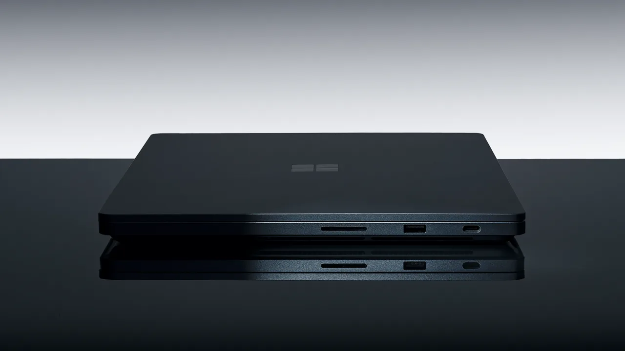 A closed black Surface Laptop Ultra on a glossy surface, seen side-on, showing a card slot, a USB-A port and a USB-C port.